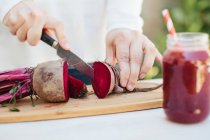 Female hands cutting fresh beet — Stock Photo