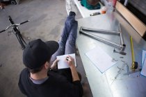 Artesãos escrevendo medidas no notebook — Fotografia de Stock