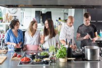 Шеф-кухар навчає людей на кухні — стокове фото