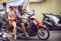 Homem dirigindo família de moto — Fotografia de Stock