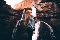 Schöne Frau in der Nähe des malerischen Wasserfalls — Stockfoto