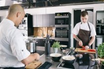 Chef e estudante de cozinha na cozinha — Fotografia de Stock
