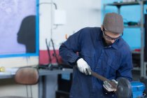 Homme en capuchon travaillant avec du métal — Photo de stock
