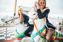 Beautiful women having fun on carousel — Stock Photo