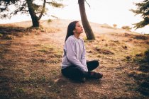 Attractive girl in lotus position at sunset — Stock Photo