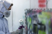 Homem no respirador pintura na parede — Fotografia de Stock