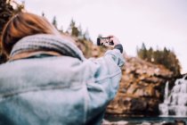 Woman taking selfie near waterfall — Stock Photo