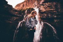 Beautiful woman near picturesque waterfall — Stock Photo