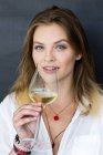 Glückliches blondes Mädchen mit einem Glas Wein — Stockfoto