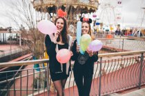 Усміхнені дівчата в масках тримають повітряні кулі — стокове фото