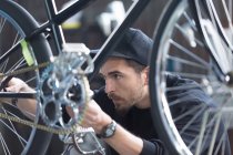 Constructor of bicycles looking at chain — Stock Photo