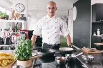 Bello cuoco in piedi in cucina — Foto stock