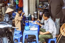 Clientes em banca de rua em Hanói — Fotografia de Stock