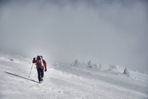 Homem caminhadas em montanhas nevadas — Fotografia de Stock