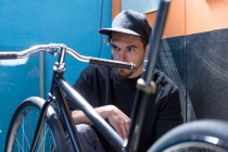 Artesanato em boné olhando para a bicicleta — Fotografia de Stock