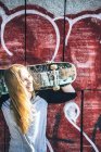 Cool skateboard woman at a public graffiti park — Stock Photo
