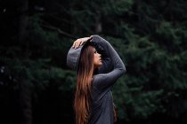 Chica en sombrero contra el bosque - foto de stock