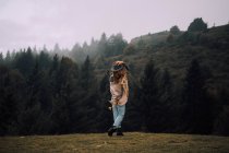Mädchen gegen nebligen Bergwald — Stockfoto