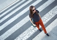 Mujer joven en el paso de peatones - foto de stock