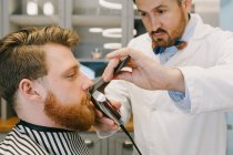 Barbiere che organizza baffi — Foto stock