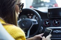 Frau benutzt Handy im Auto — Stockfoto
