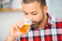 Bearded man smelling craft beer — Stock Photo