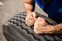 Bodybuilder with hands on tyre — Stock Photo