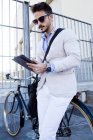 Молодий бізнесмен стоїть з велосипедом — стокове фото
