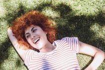 Женщина лежит на траве и смеется — стоковое фото