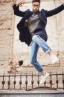 Trendy man with coat jumping — Stock Photo