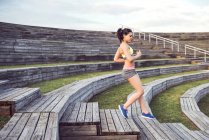 Athlete running at wooden stairs. — Stock Photo