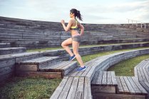 Atleta corriendo en escaleras de madera - foto de stock