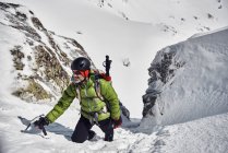 Homem escalando na montanha nevada — Fotografia de Stock