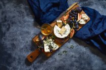 Queso con uvas, higos sobre tabla de madera - foto de stock