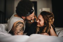 Couple souriant sur le lit — Photo de stock
