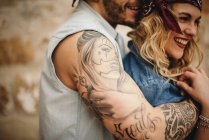 Парень обнимает свою улыбающуюся девушку — стоковое фото