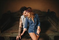 Abbracciare coppia seduta sul vecchio letto — Foto stock