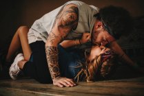 Couple kissing on wooden bed — Stock Photo