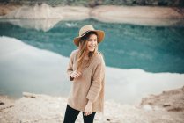 Donna allegra in cappello contro di lago — Foto stock