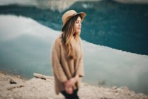 Donna allegra in cappello contro di lago — Foto stock