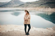 Стильная женщина против озера — стоковое фото