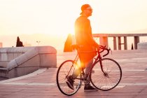 Чоловік гуляє з велосипедом у міському парку — стокове фото