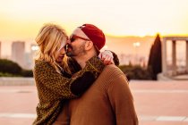 Casal abraçando o pôr do sol urbano — Fotografia de Stock