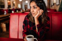 Girl in cafe with cup of coffee — Stock Photo