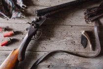 Открытая винтовка и посуда на столе — стоковое фото