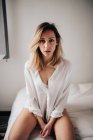 Приваблива жінка сидить на ліжку — стокове фото