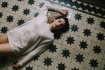 Жінка лежить на підлозі — стокове фото