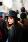Young woman looking back in crowd — Stock Photo