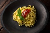 Spaghettis à la sauce et basilic sur assiette — Photo de stock