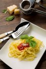 Spaghetti with tomato sauce on square plate — Stock Photo